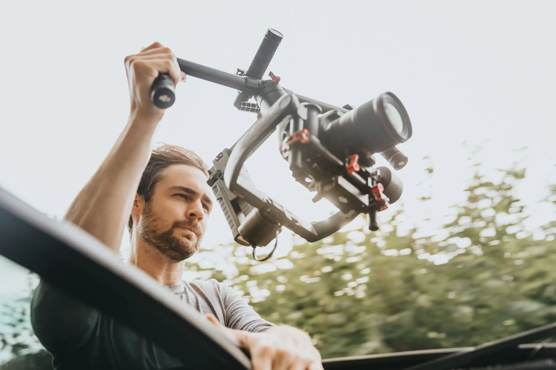 Man recording video with stabilizer in car