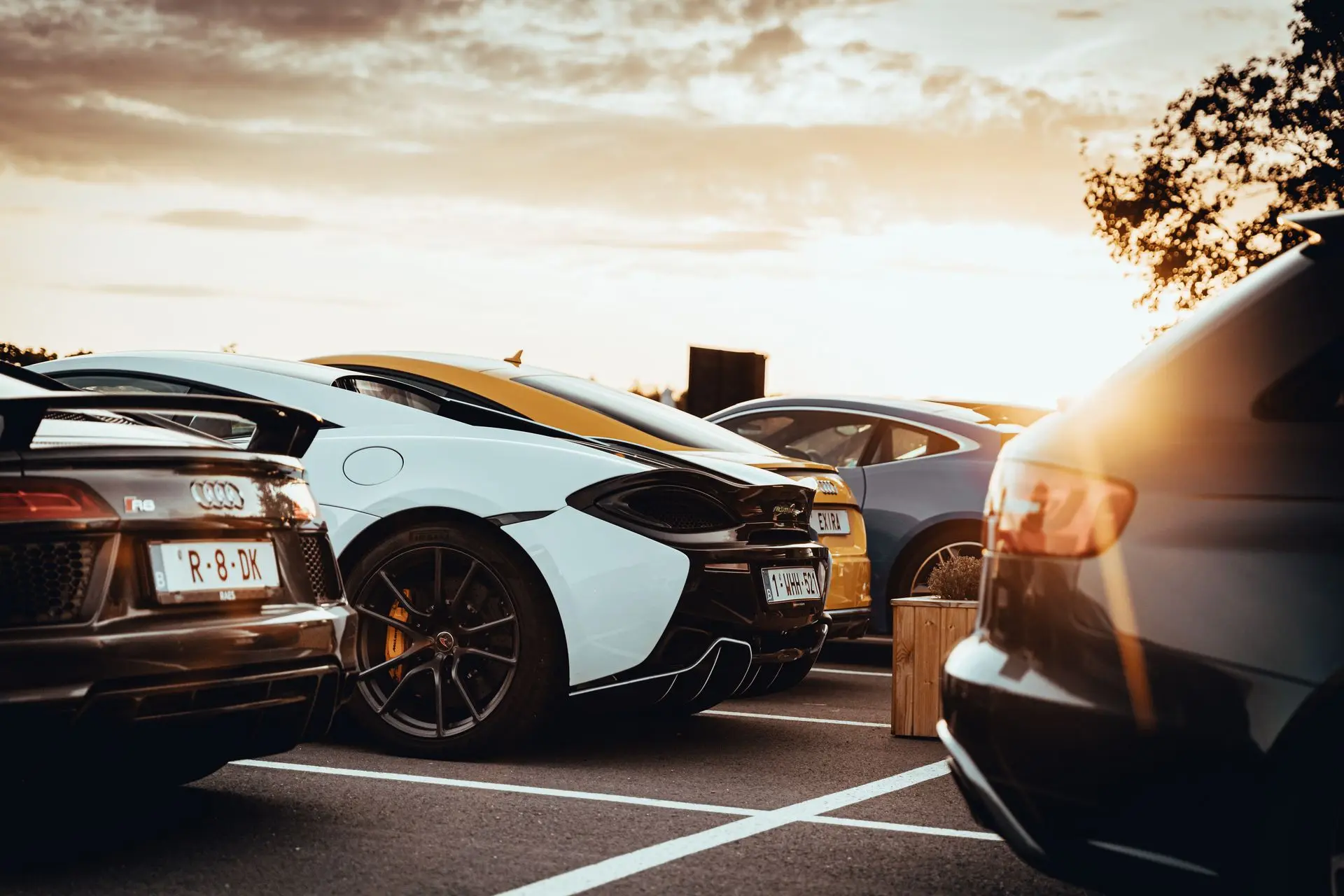 Audi R8 and Mclaren parked up with sunset in the back