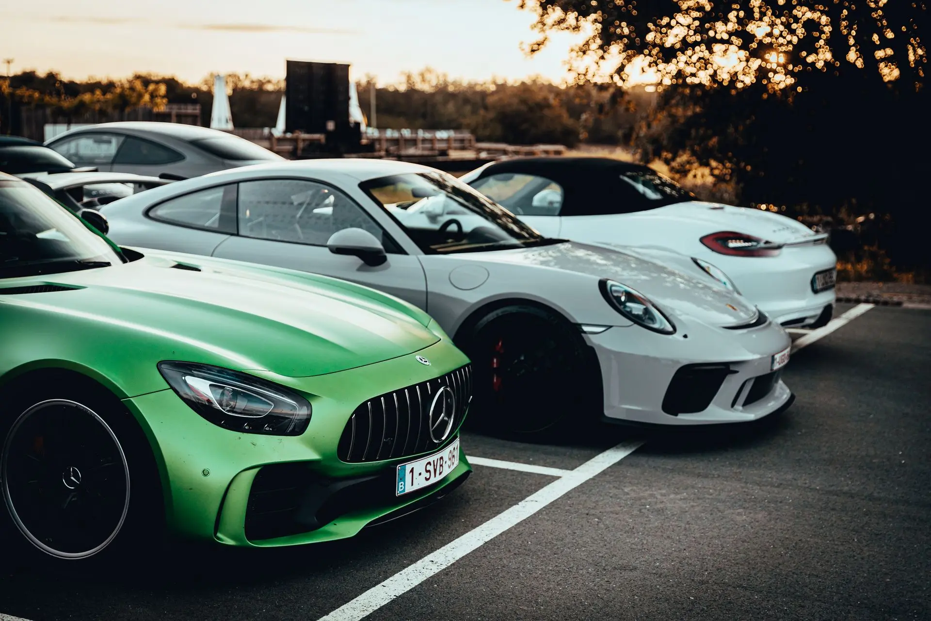 Porsche 911 and green mercedes AMG parked up