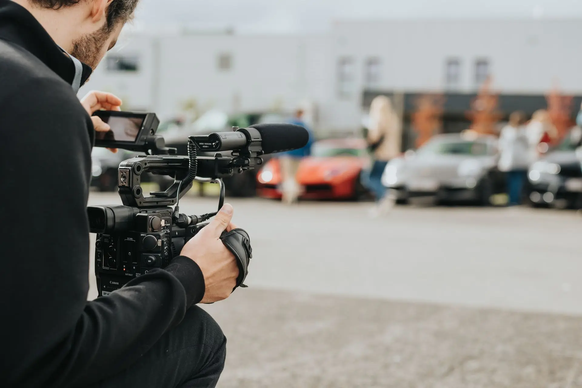 Videographer filming sports cars