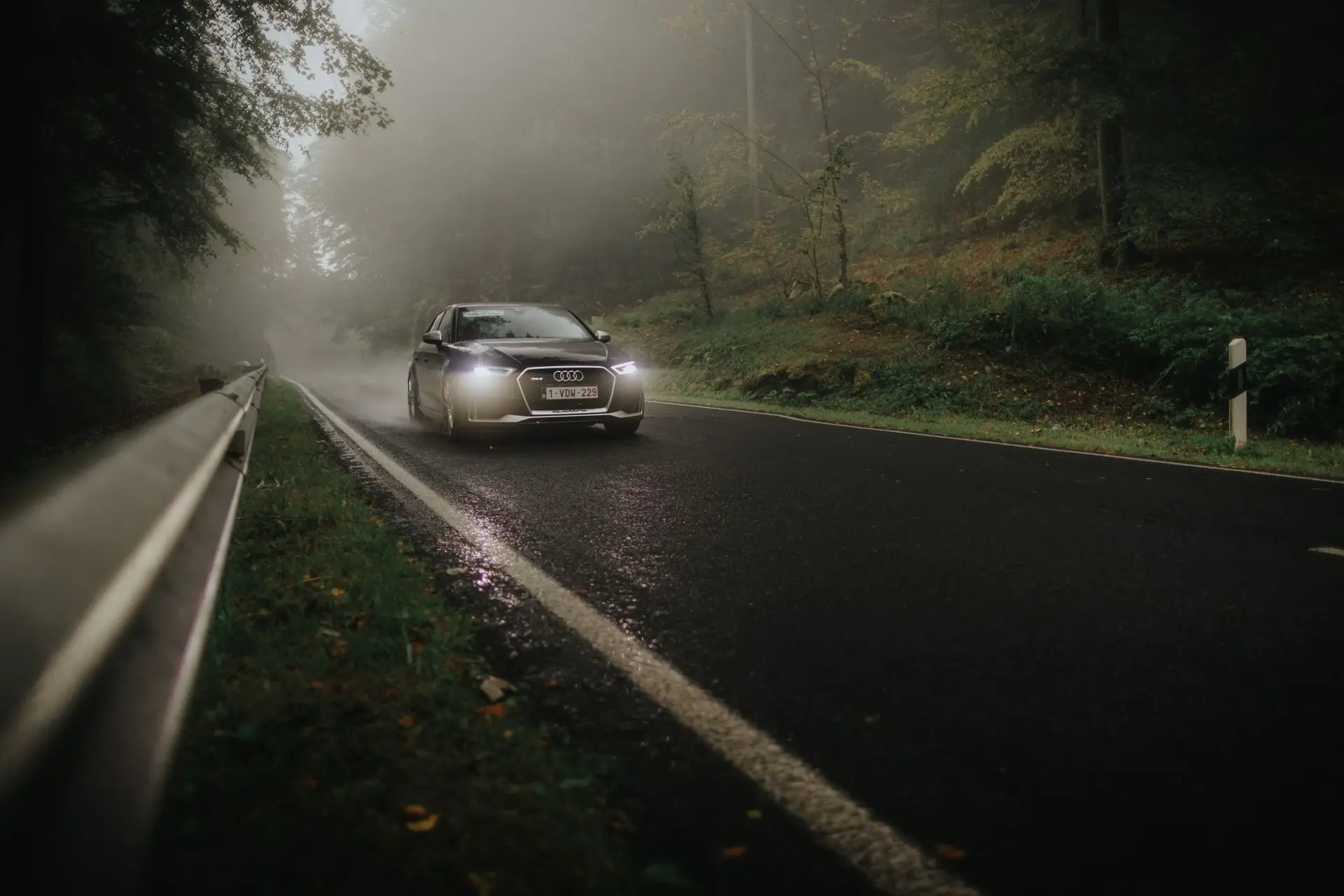 Black audi RS3 driving through foggy forest