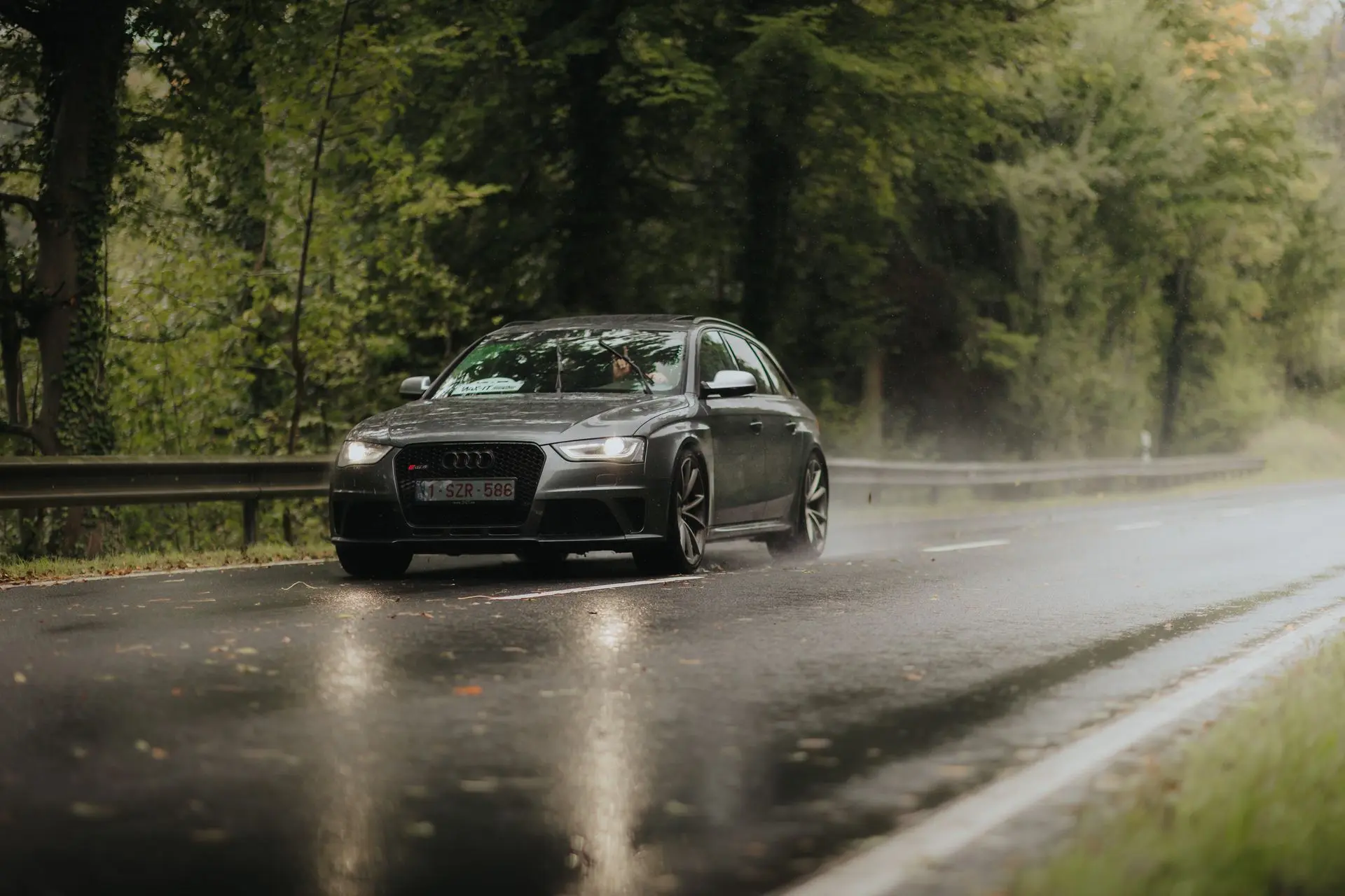 Audi RS4 driving trough the rain in the forest