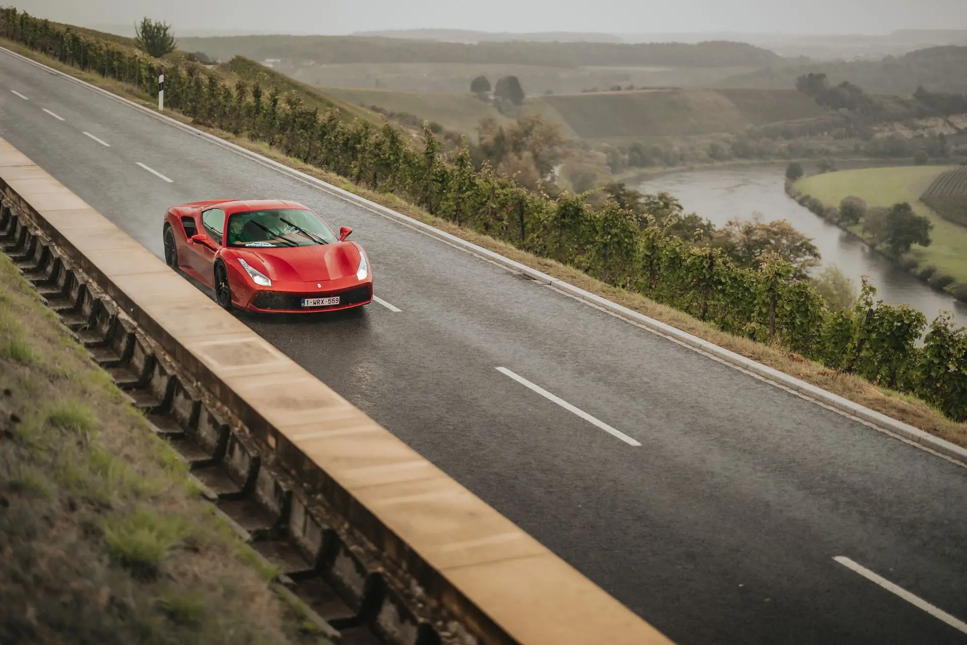 Ferrari 456 driving on wet road country side